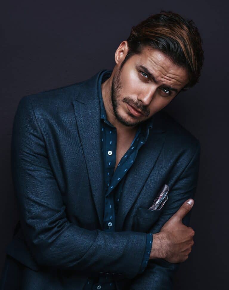 Stylish man in a sharp blue suit showcasing expertly crafted brown highlights from the best men's barbershop in Dubai. Elevate your look with our exceptional grooming services and contemporary styling.