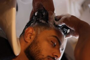 Professional barber providing a refreshing hair wash experience at the best men's barbershop. Enjoy top-notch grooming services and exceptional care for your hair