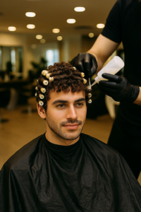 Client receiving a Korean men’s perm in Dubai at GQ Men’s Hair Lounge, stylist creating soft waves using smaller rods for natural texture.