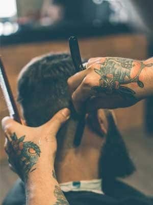 Barber giving a precise haircut at GQ Men's Hair Lounge in JLT Dubai