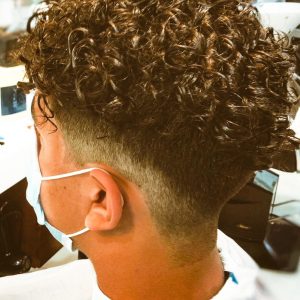 Boy with perm and fade haircut styled at GQ Men's Hair Lounge in Dubai